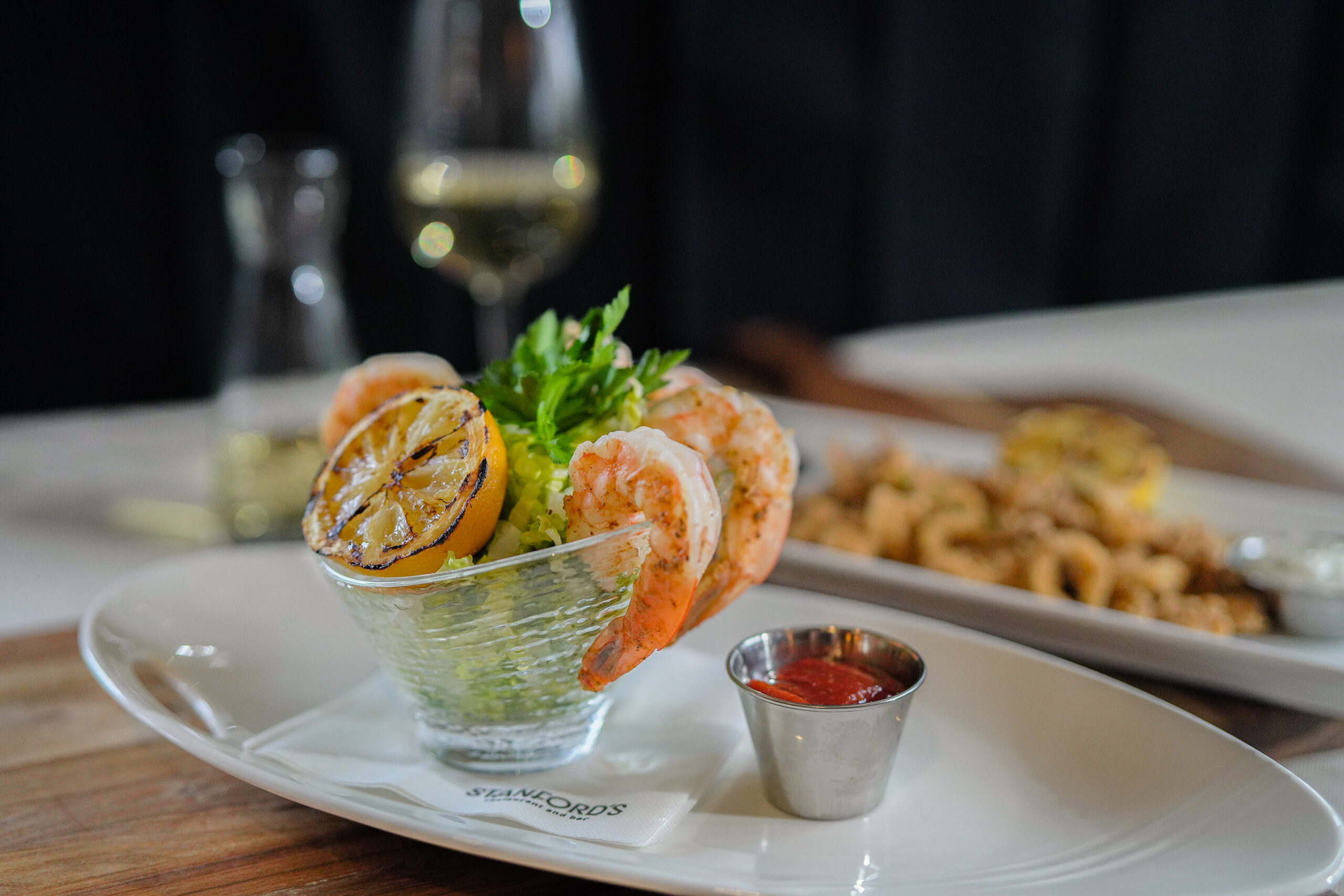 AboutUs_FeaturedImagebelowTeamphoto shrimp appetizer in cup with large cooked shrimp